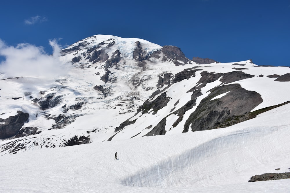 person walking on mountain covered by snow