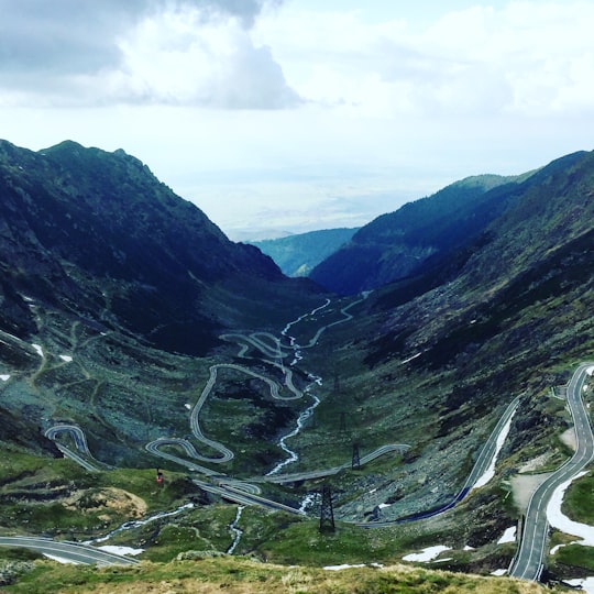 landscape photography of road between mountains during daytime in Transfăgărășan Romania