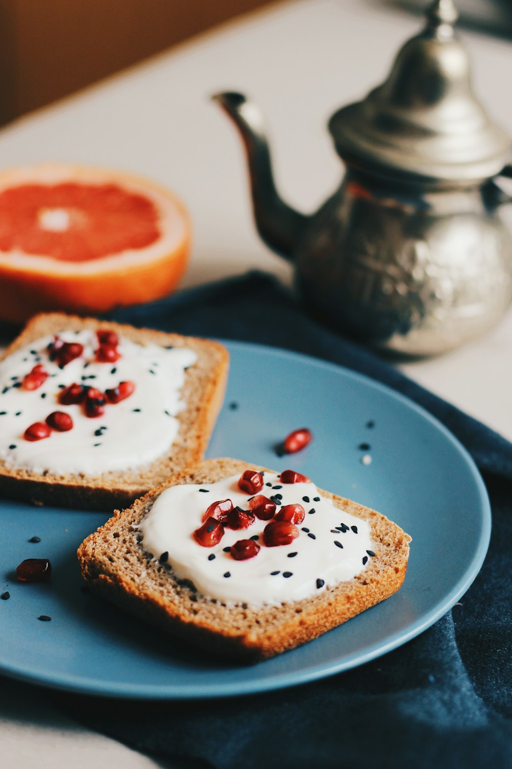 Flatlay-Fotografie von gestrichenem Brot neben Teekanne