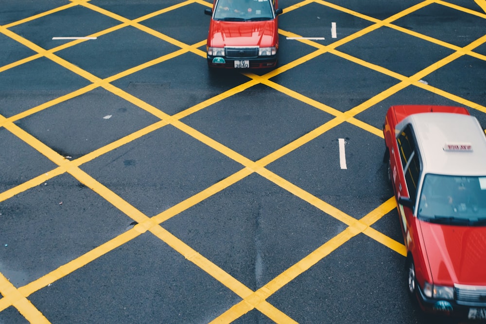 two red vehicles on gray and yellow concrete road