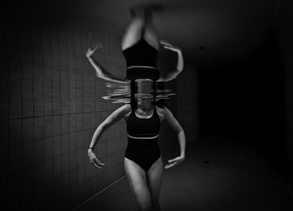 grayscale photo of woman wearing monokini on body of water