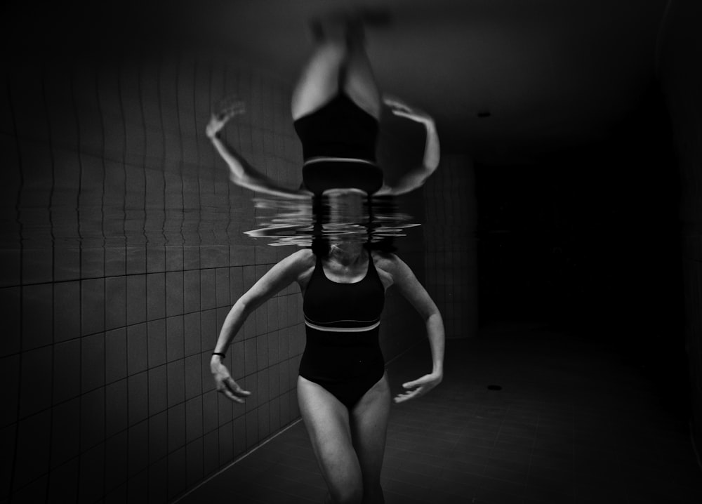 foto em tons de cinza da mulher usando monokini no corpo da água