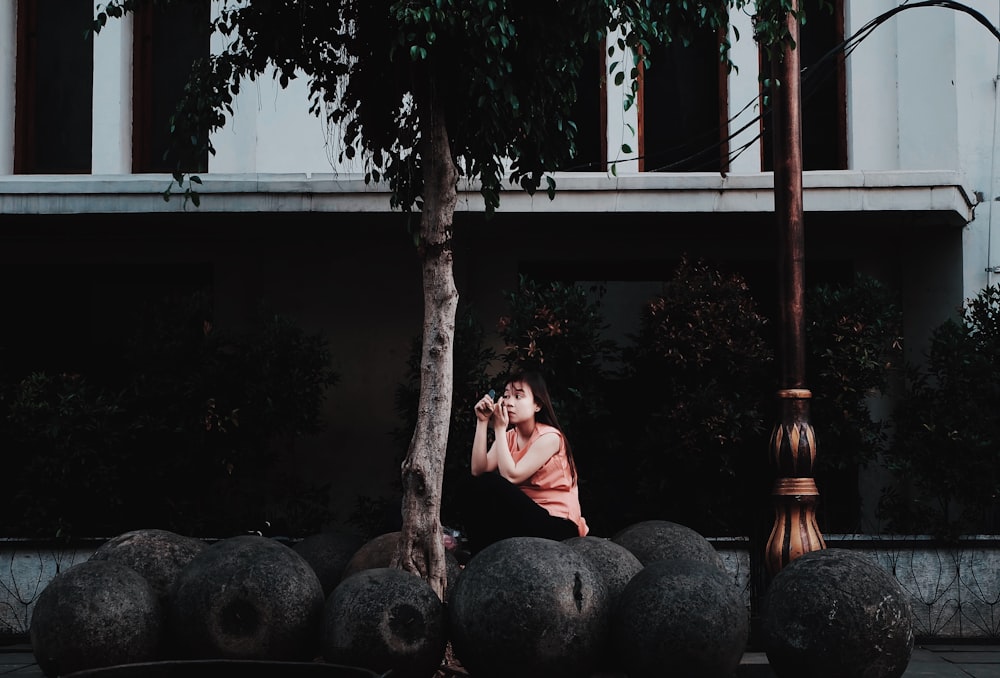 woman sitting on black stones