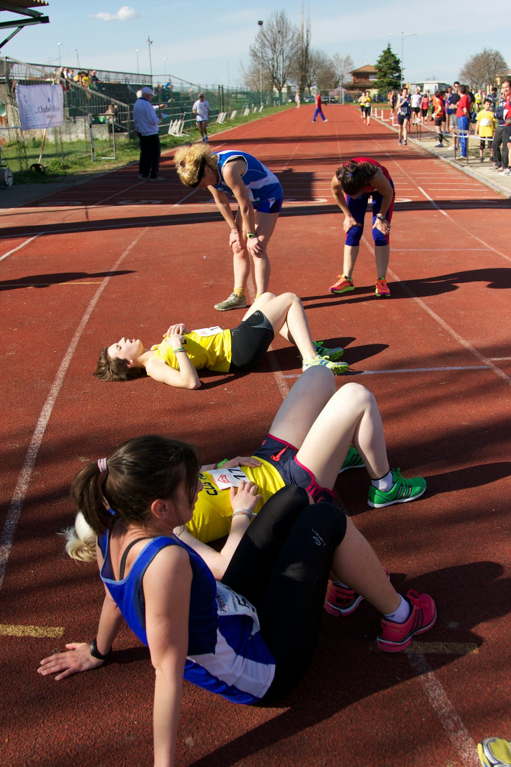 five women standing on brown track and field