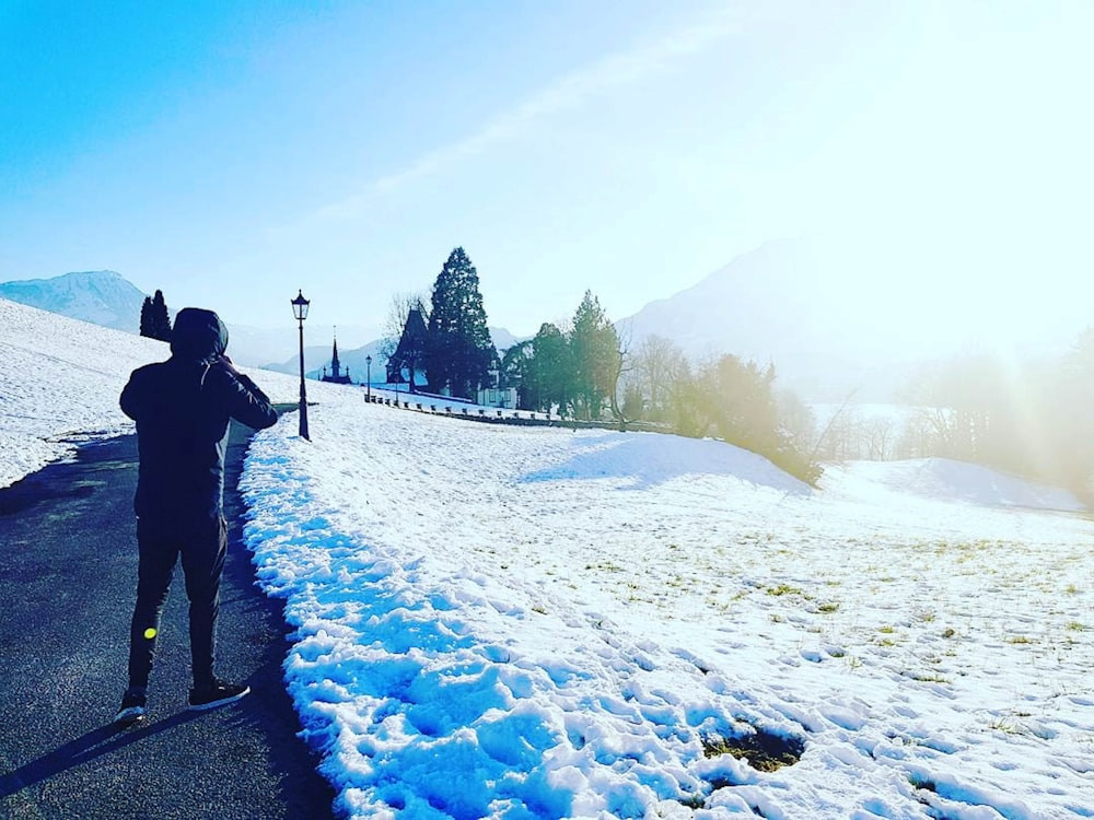 man walking on path beside snow