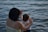 woman holding girl near body of water