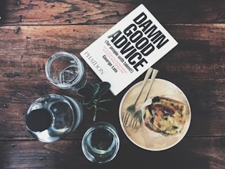 Table with documents, a book on professional advice, and water glasses, illustrating expert guidance