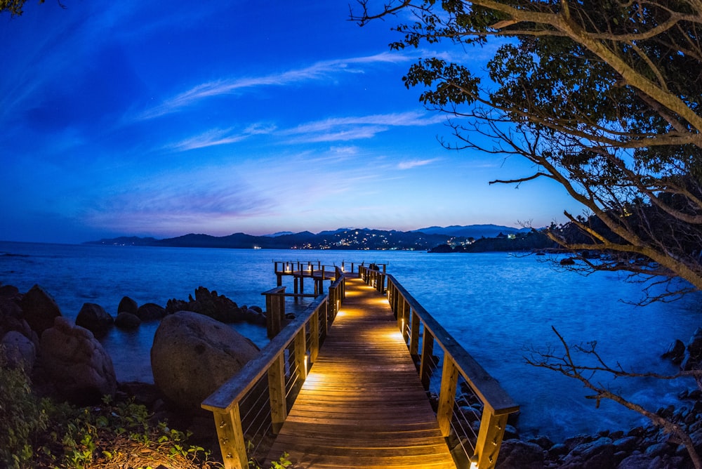 brown dock with light beside rock formation at daytime