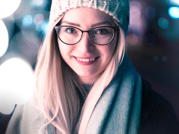 Close-up of Shaira Arshi smiling softly in a cozy knitted hat.