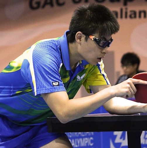 table tennis player serving front of table