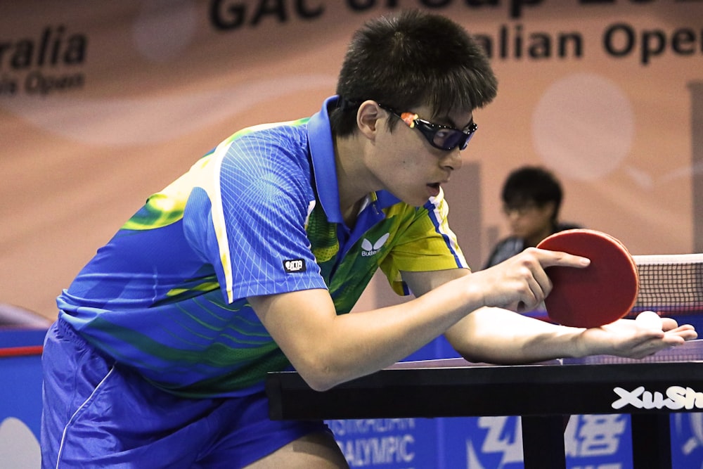 table tennis player serving front of table