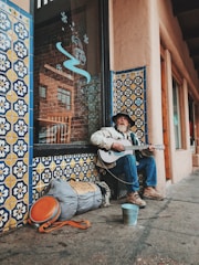 man playing guitar on street