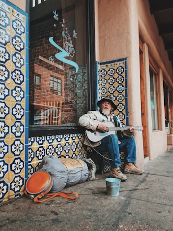 man playing guitar on street