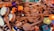 A collection of wooden spoons scattered with vibrant wooden toys and tambourines intermixed. The toys are brightly colored, featuring elements like an orange animal, drumheads, and decorative flowers.