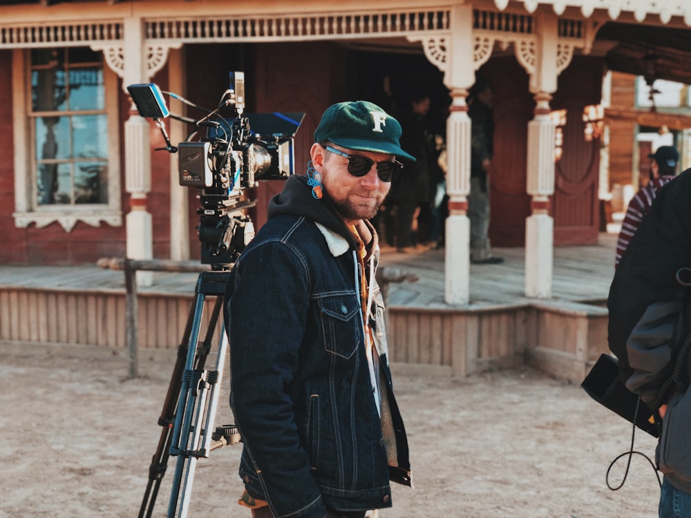 man in jacket beside camera