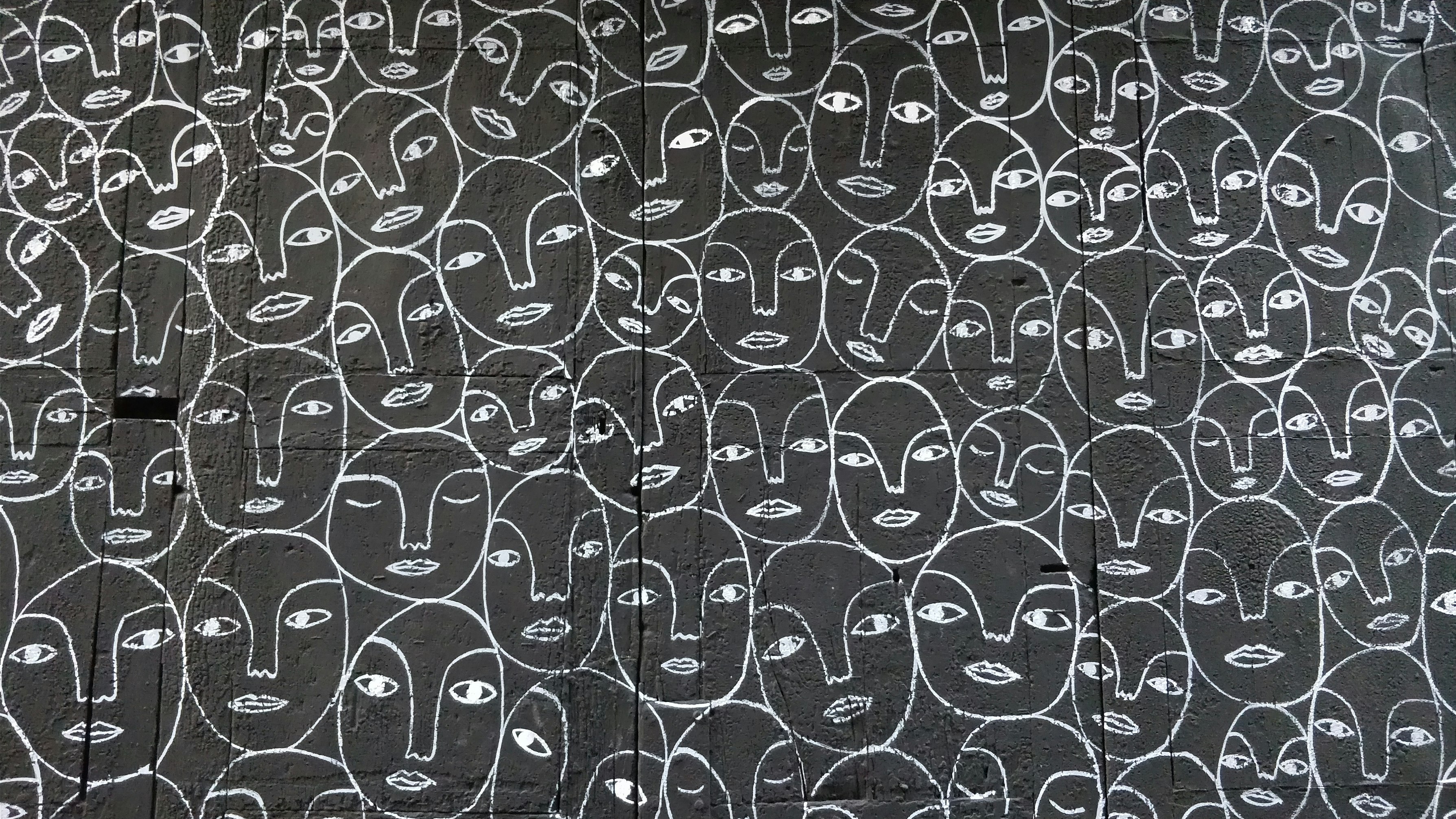 visages à la craie sur mur d'ardoise