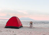 Spacious dress changing tent open on a sandy beach at sunset.
