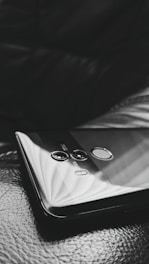 A close-up of a hand using fingerprint authentication on a sleek smartphone.