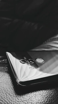 A close-up shot of two smartphones displaying different apps, placed on a textured surface with subtle reflections.