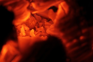 Close-up of warm glowing biomass pellets spilling from a rustic wooden container.