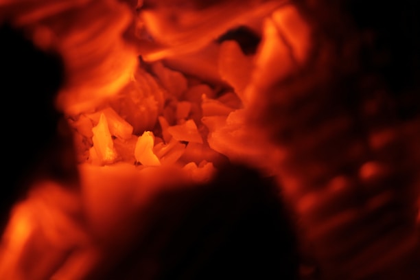 Close-up of glowing mesquite charcoal embers radiating warm orange light.