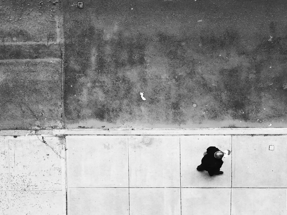 man walking on tiled pathway