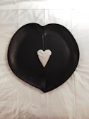 Close-up of a heart-shaped ceramic plate with a smooth matte finish and subtle texture.