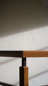 A sleek architectural model displayed on a minimalist wooden table casting soft shadows in natural light.