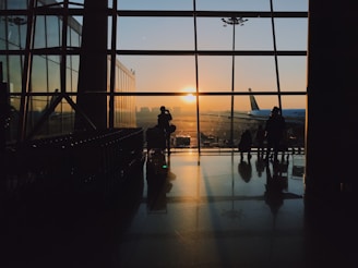 silhouette of people standing inside airport during golden hour