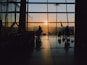 silhouette of people standing inside airport during golden hour