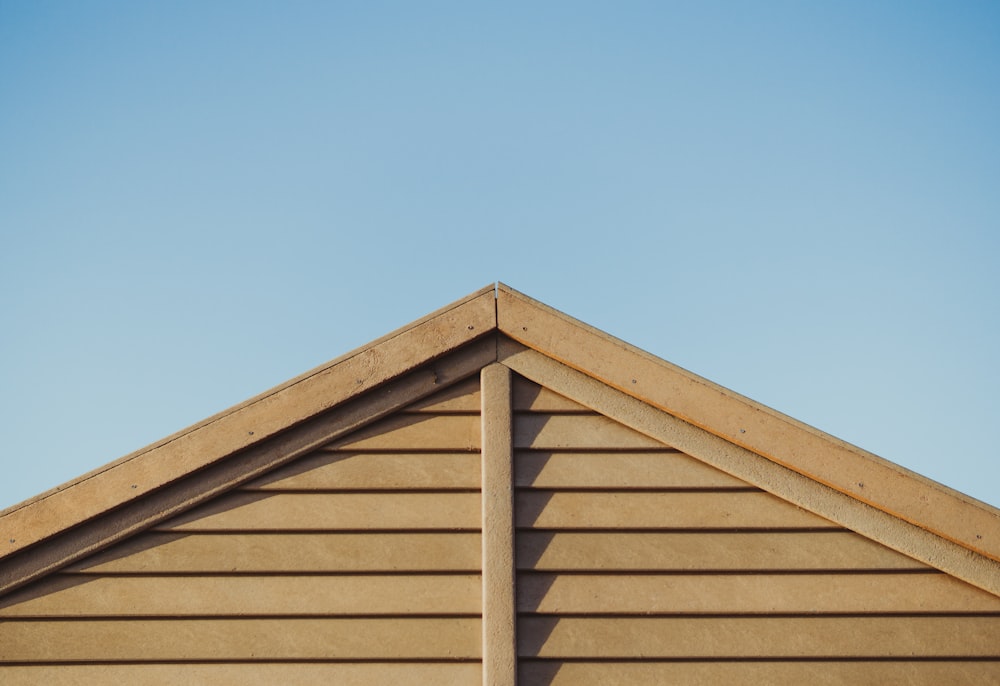 photo of brown wooden house roof under clear blue sky