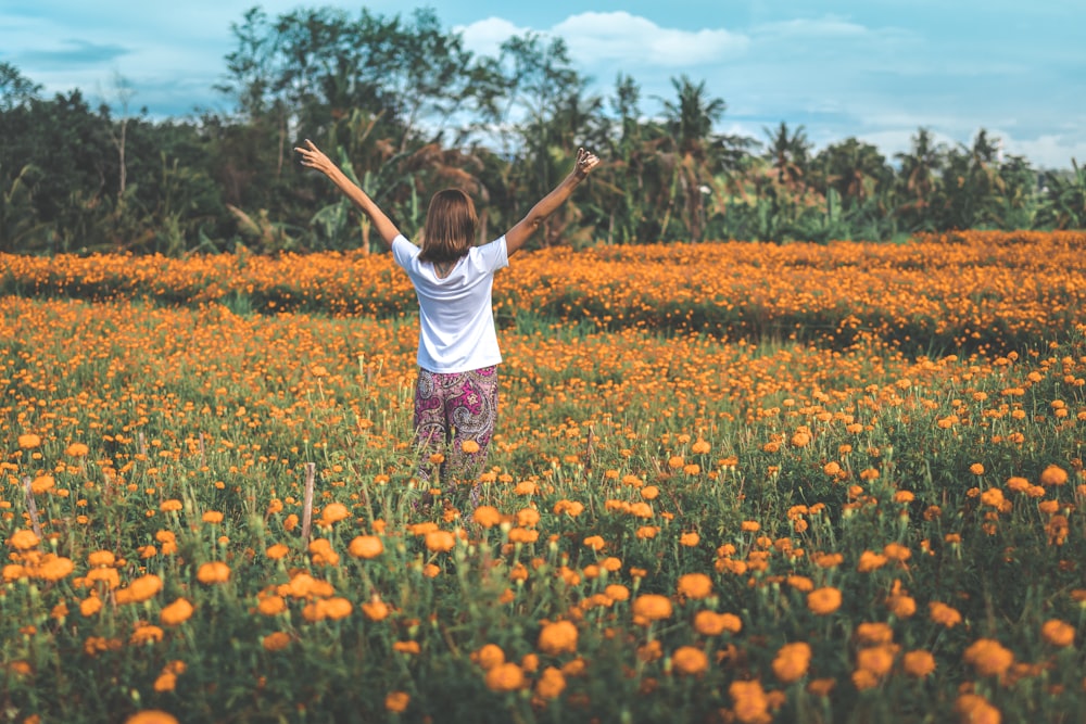 Mujer de pie en el campo de flores de naranjo durante el día