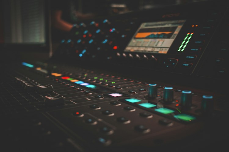 A musician's home studio setup with a laptop, headphones, and audio interface