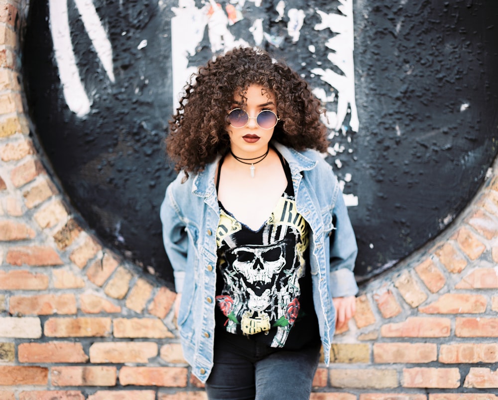 woman leaning on brick wall