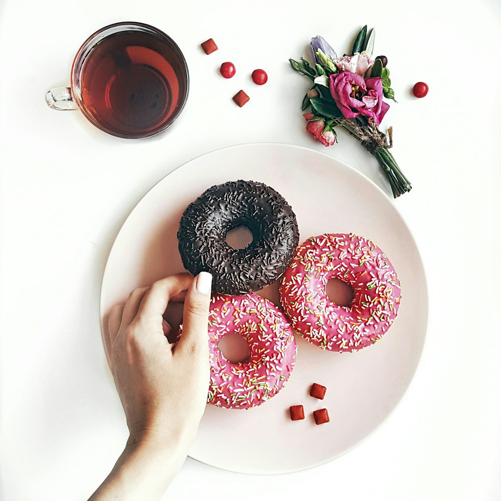 person holding black donuts