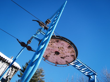 Close-up of a modern cable car pulley system against a clear blue sky.
