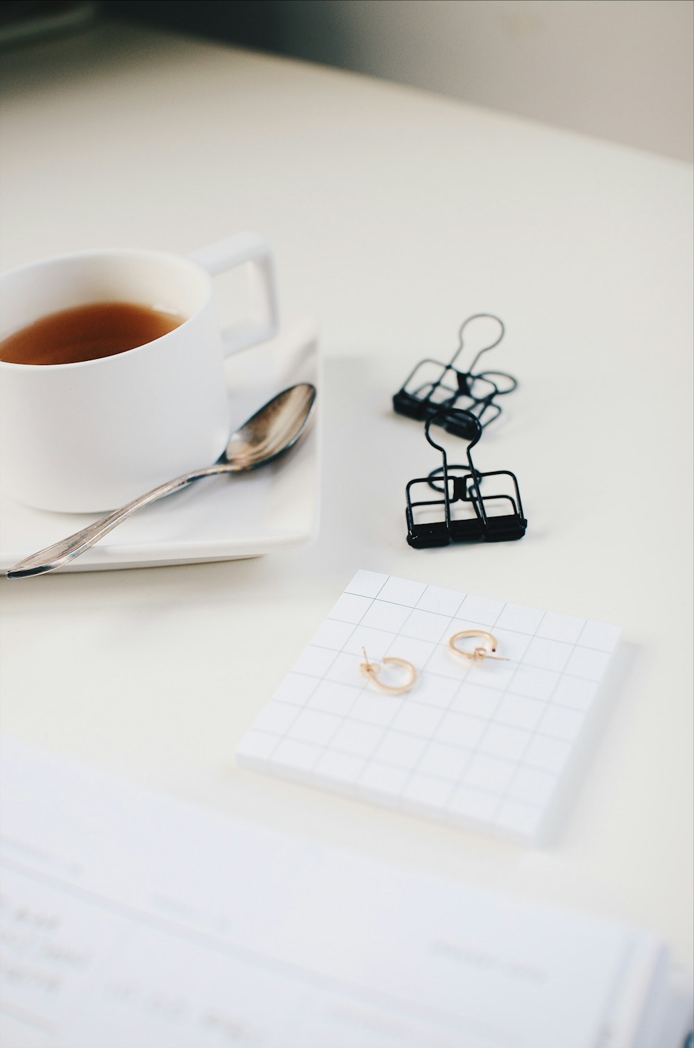 cup of tea with two black paper clips