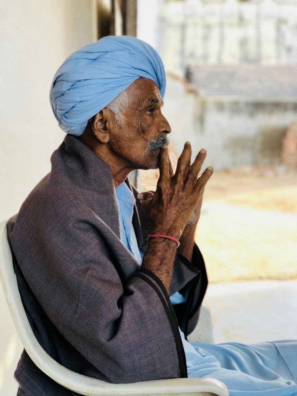 man in black jacket sitting on white monobloc armchair