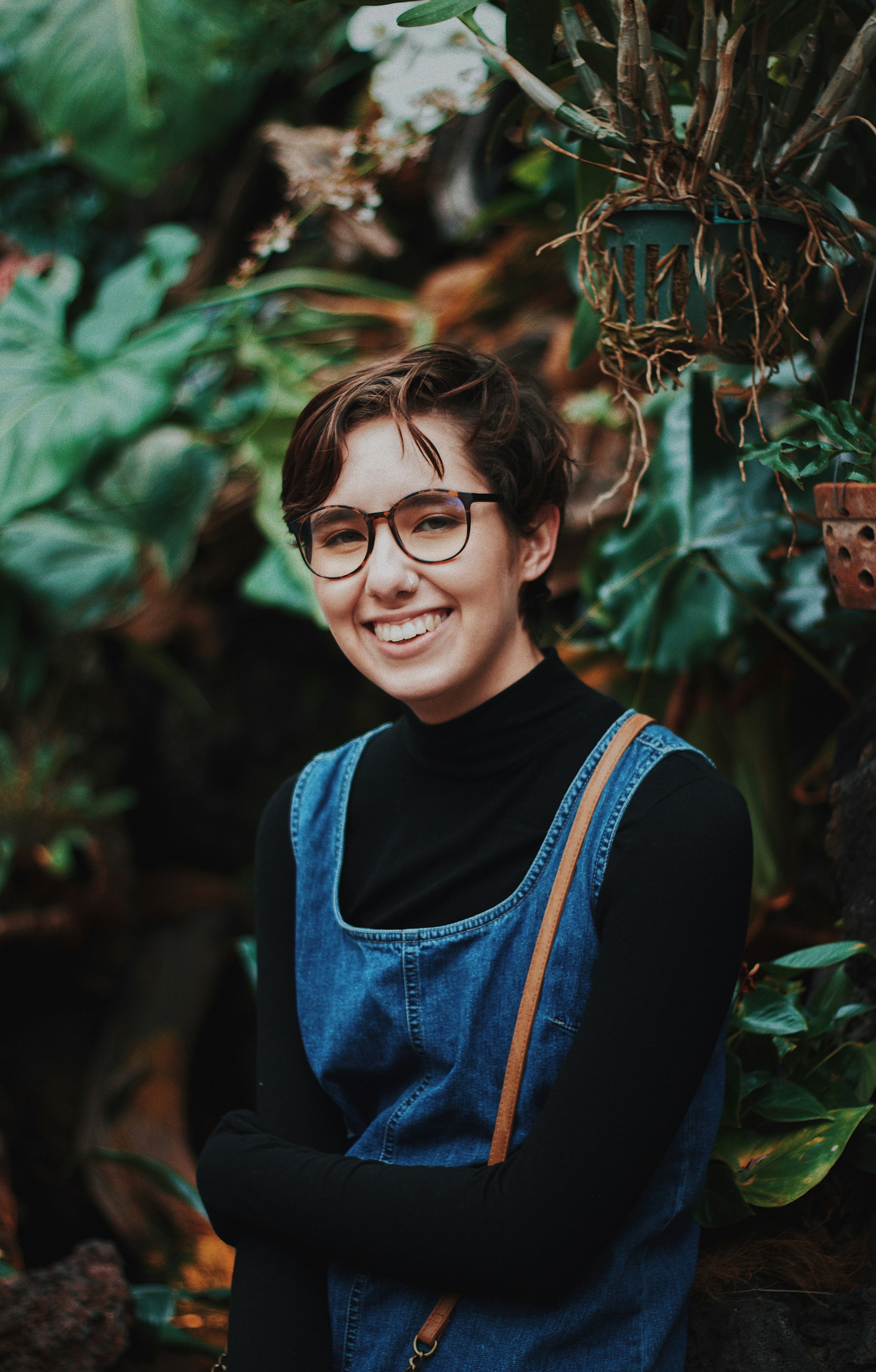 selective focus photography of woman standing in front of plants