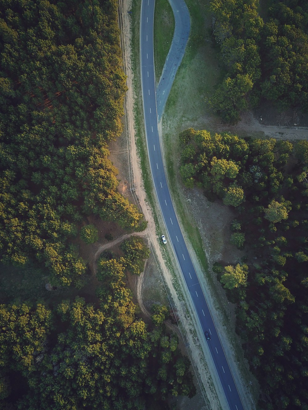 high angle photo of vehicles passing on asphalt road