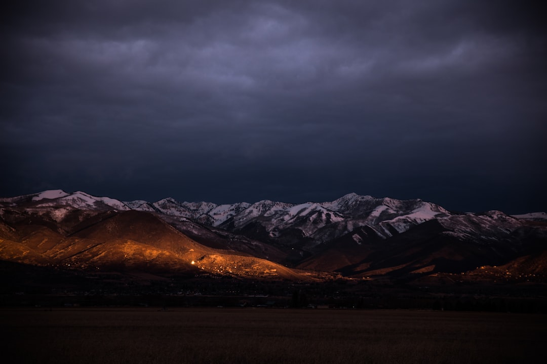 brown mountain under gray clouds during golden hour