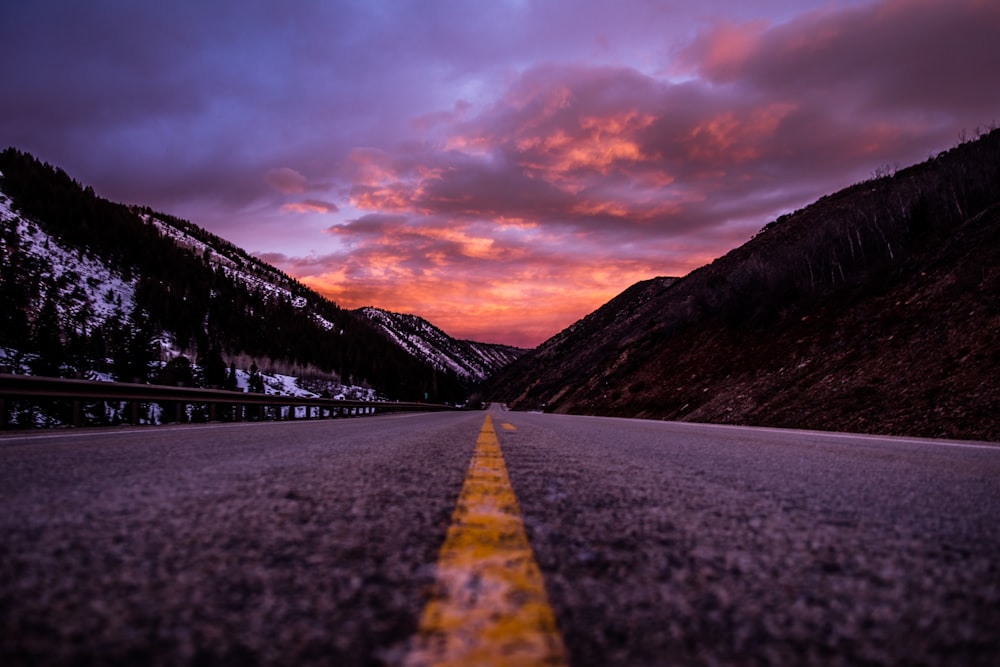 road between mountains under cloudy sky