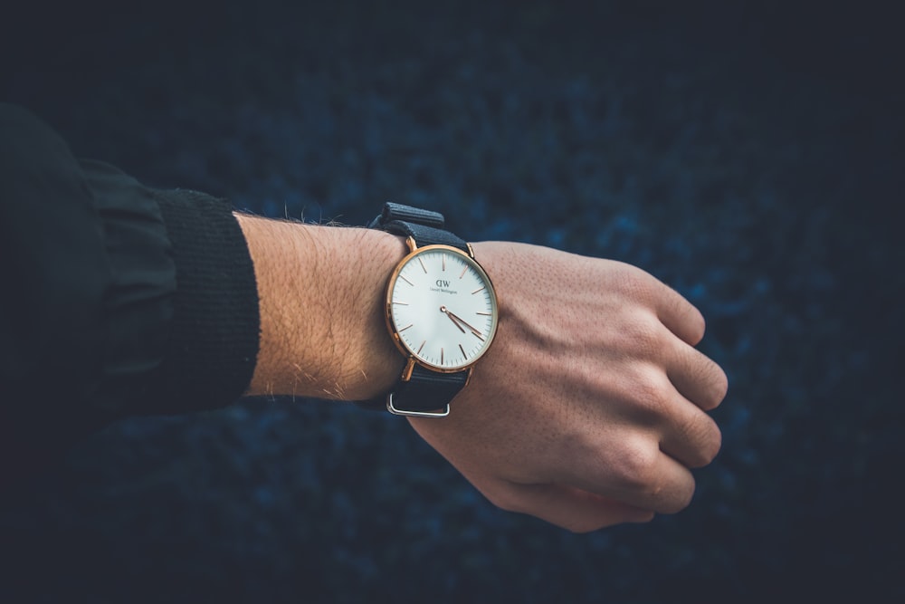 person wearing round analog watch