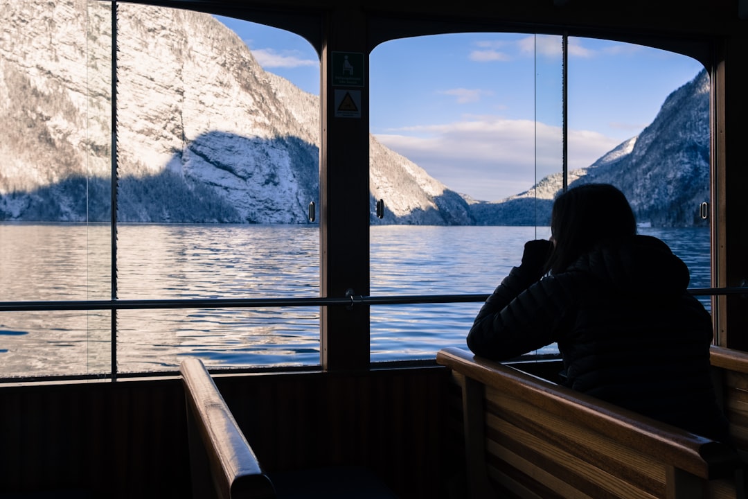 person sitting inside boat near window, Woman thoughtfully admires a lake view from boat.