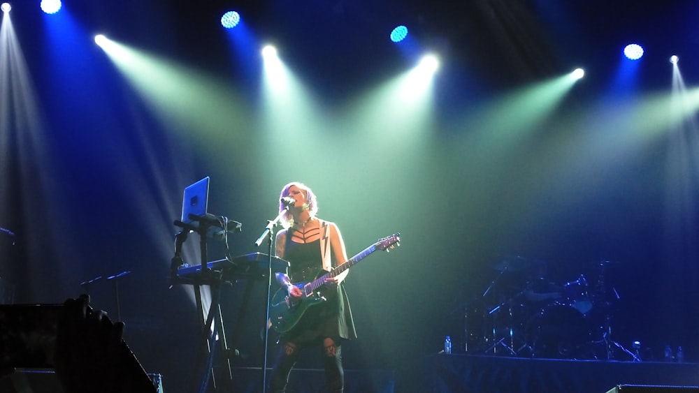 woman playing guitar on stage