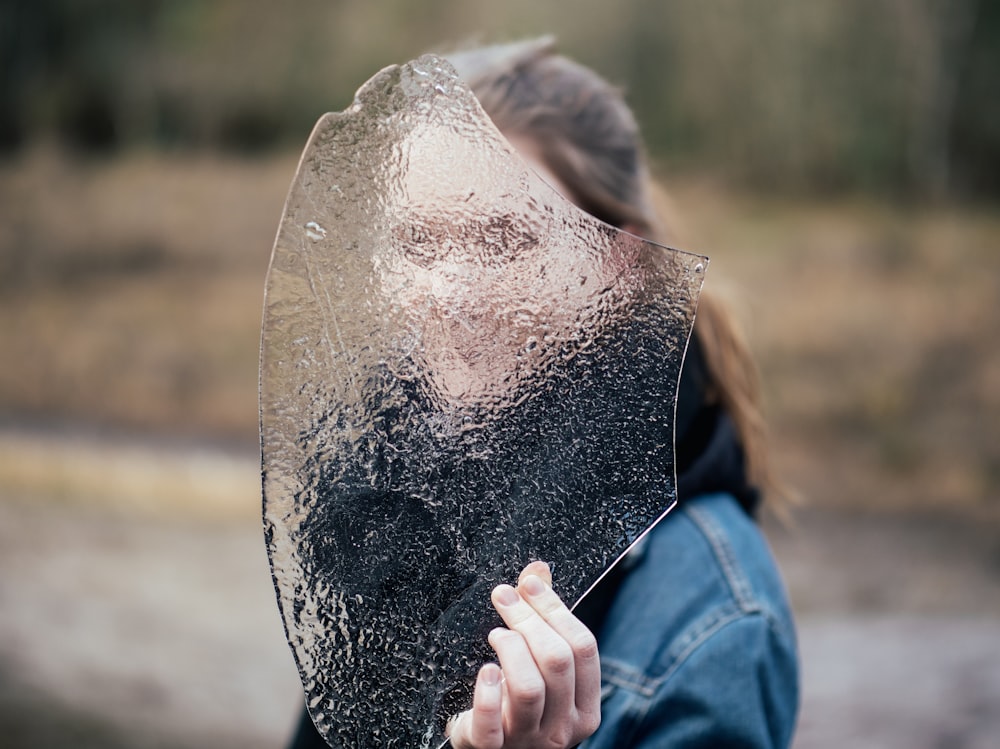 donna che copre il viso con vetro smerigliato