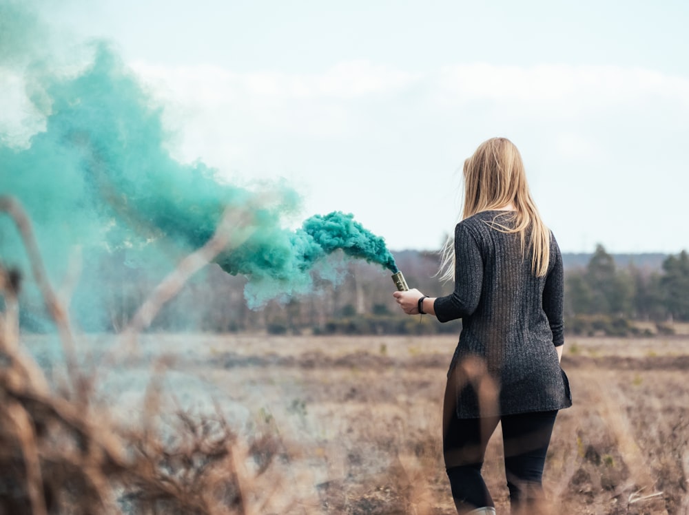 Mujer sosteniendo una bomba de humo verde