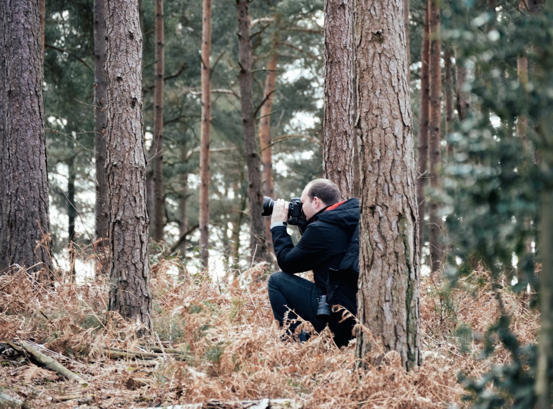 man taking picture in the woods using a DSLR camera