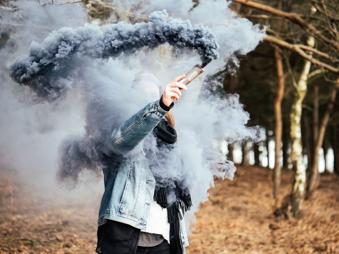 person holding gray ash flare standing on brown ground