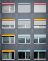 photo of gray concrete building with clear glass windows during daytime